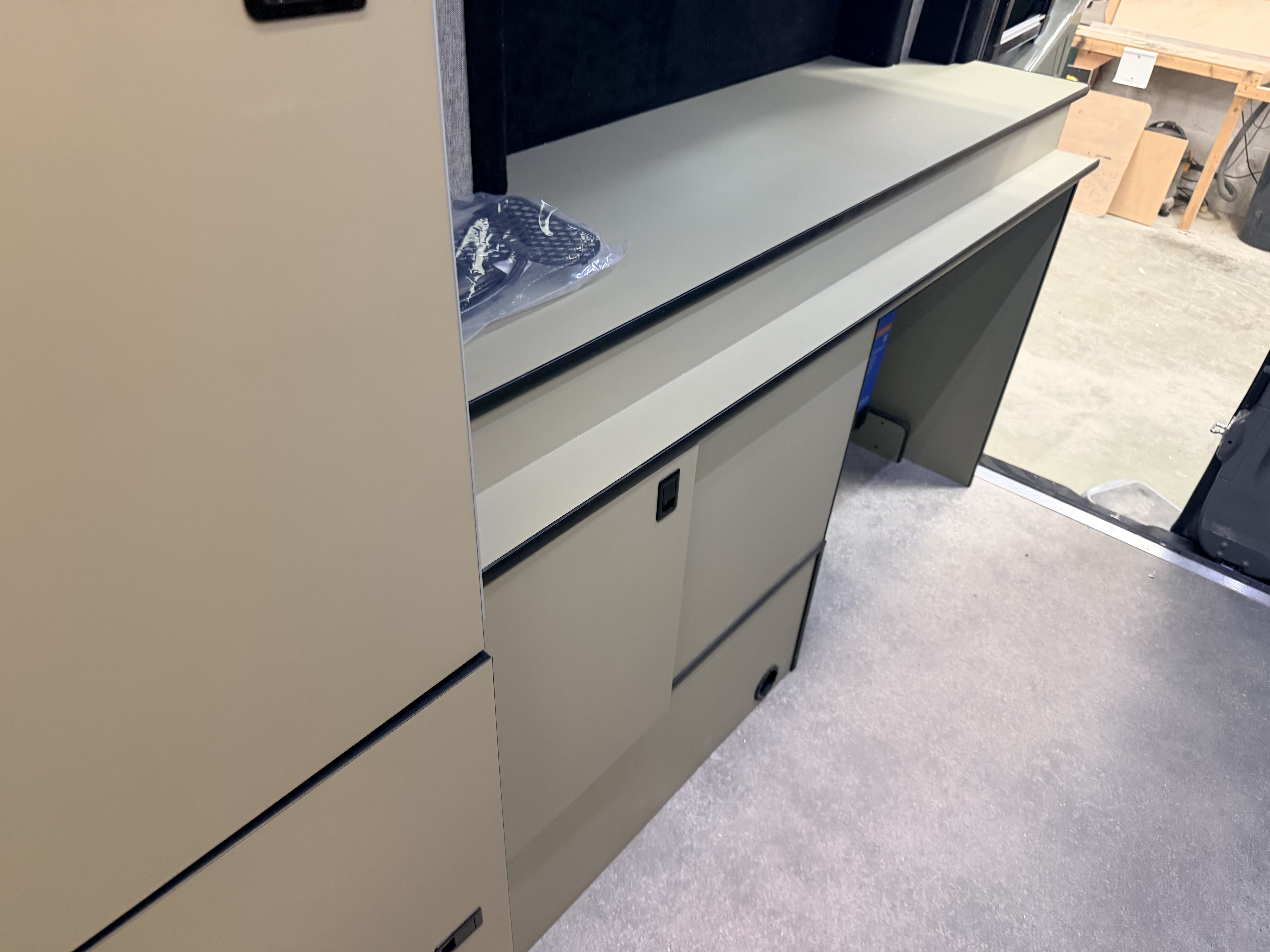 Ridgeline 002 Iron Trail interior cabinetry — hand-finished tan panels and dark worktop surface built in-house